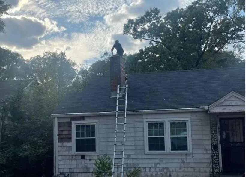 Jade Chimney technician working on a rooftop chimney