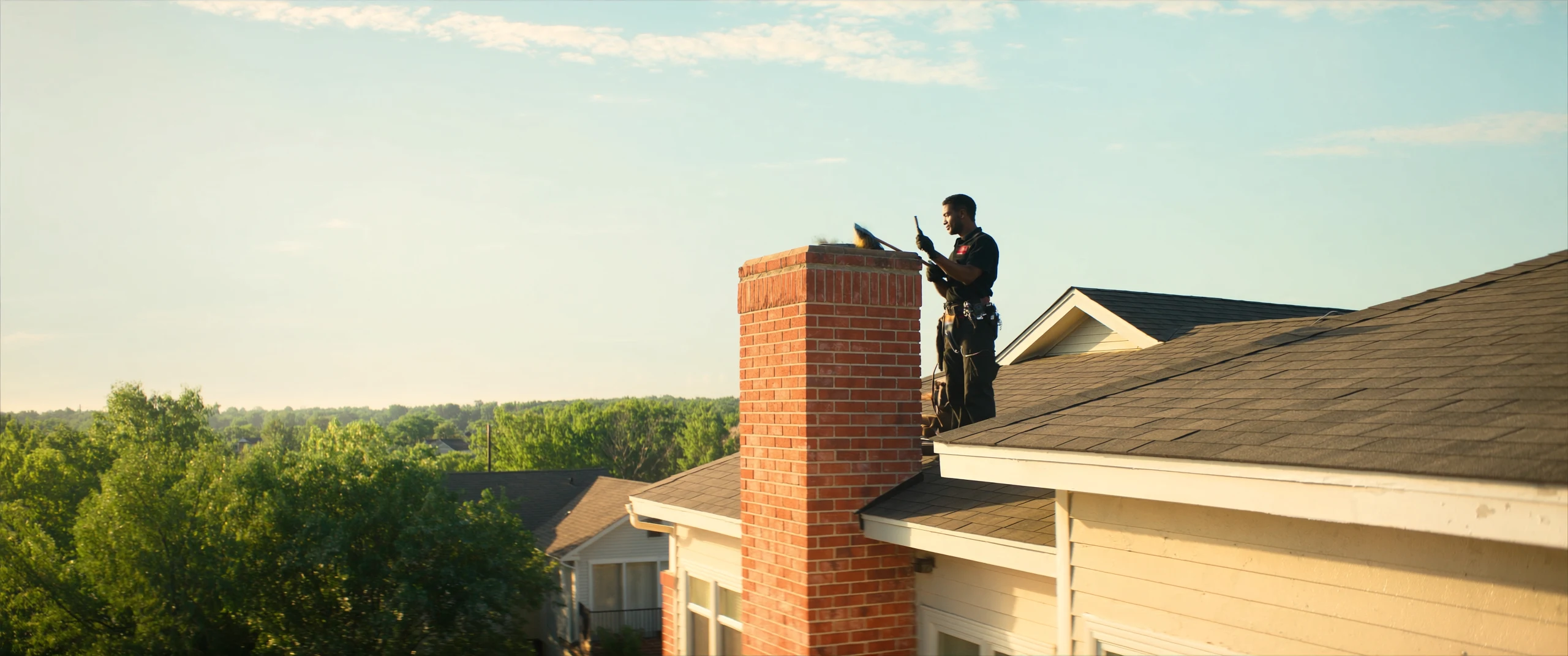 Chimney sweep on a rooftop at golden hour